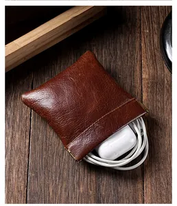 Gros plan d'une pochette de rangement en cuir marron avec fermeture à ressort et câbles