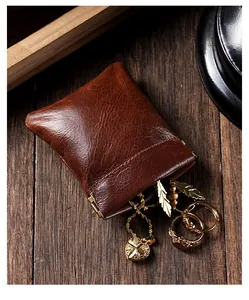 Gros plan de qualité d'une pochette à bijoux en cuir vintage marron avec bijoux dorés.
