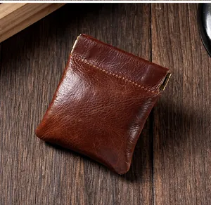 Gros plan d'une pochette vintage en cuir ciré marron avec fermeture automatique