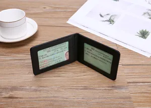 Close-up detail of a minimalist black faux leather driver's license holder on a wooden desk setup.