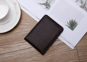Close-up of slim dark brown textured leather driver's license holder on a wooden desk