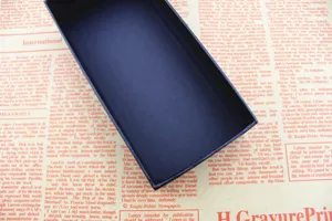 Scatola regalo rettangolare nera opaca vuota su sfondo di giornale vintage dettaglio