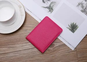 Detailed macro view of a fuchsia leather driving license sleeve on a wooden desk