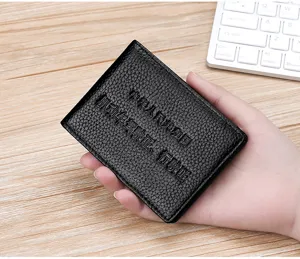 Detailed view of the black litchi grain leather driver's license cover held in hand