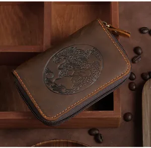 Close-up detail of a vintage brown leather card holder featuring an embossed dragon motif