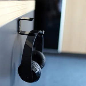 Minimalist black acrylic L-shaped headphone hanger hook installed on a desk edge surface