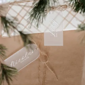 Primer plano de etiquetas de regalo de acrílico esmerilado en cajas de Navidad