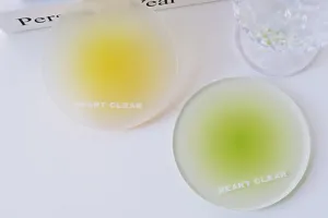 Macro detail view of frosted acrylic coasters with yellow and green gradient color designs