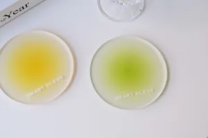Close-up view of circular frosted acrylic coasters with yellow and green gradient centers.