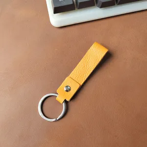 Primer plano de un llavero de cuero auténtico amarillo con su textura de grano fino