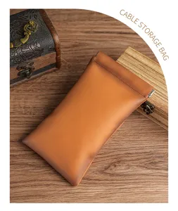 Macro view of brown leather storage bag with metal spring closure on wood background