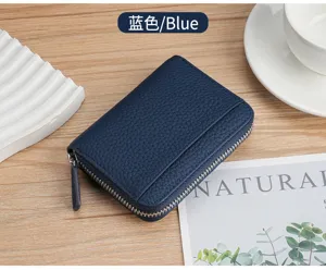 Top view of a navy blue litchi grain leather RFID card holder wallet on a wooden desk