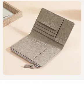 Détail du porte-passeport en cuir grainé taupe avec fentes pour cartes et zip