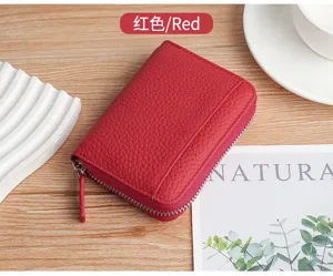 Detailed view of red litchi grain leather card holder with secure zipper closure