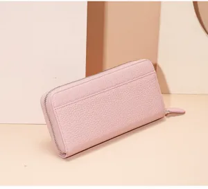 Pink genuine leather long zip wallet detail view, showing fine pebbled texture and metal zipper.