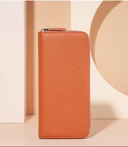Close-up view of orange pebbled leather zip wallet showing fine texture and sleek modern design.