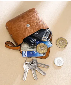 Pequeño monedero de cuero marrón con espacio para llaves de coche y tarjetas de crédito