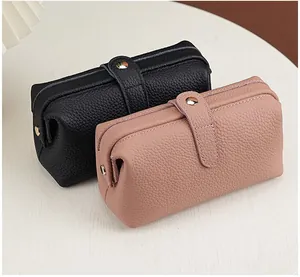 Close-up of two leather cosmetic bags featuring elegant lychee grain texture and metal buckles