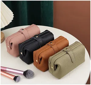 Genuine top grain leather cosmetic bags in pink, black, brown, and sage green colors.