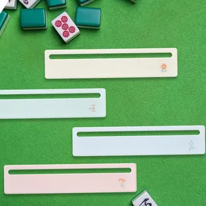 Four colorful acrylic mahjong strategy bands with delicate floral patterns on green felt.