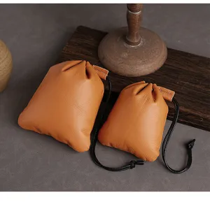 Set van twee vintage oranje lederen tassen met trekkoord voor sieraden en munten