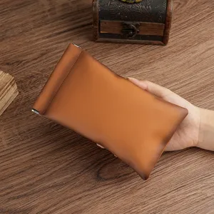 Ultra-thin brown leather coin purse with spring clip closure for glasses and storage.