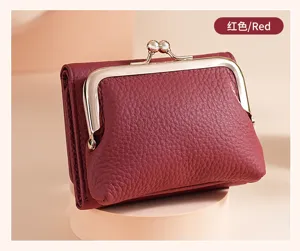 Detailed view of a red pebbled leather women's wallet with a gold kiss-lock clasp