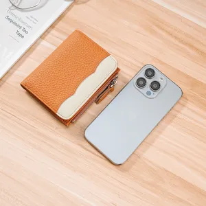 Women's orange genuine leather small wallet with coin pocket next to a smartphone.