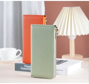 Detailansicht einer grünen Damen-Lederbrieftasche mit L-Reißverschluss und Golddetails.