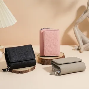 Drie minimalistische drievoudige leren portemonnees voor dames in zwart, roze en beige.