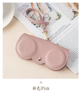 Close-up of pink pebbled leather sunglasses case with wrist strap and gold snap