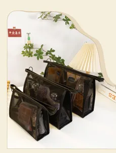 Three-piece set of black mesh makeup bags for travel cosmetic storage on a vanity