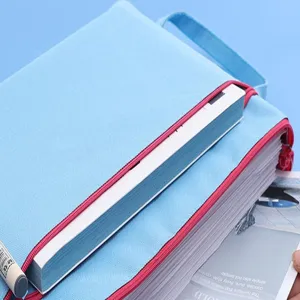 Κοντινό πλάνο μπλε υφασμάτινης τσάντας εγγράφων A4 με κόκκινο φερμουάρ και μεγάλη χωρητικότητα
