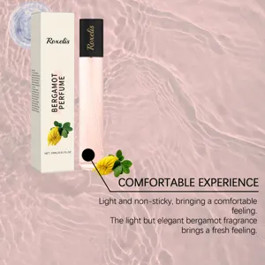 Close-up of Roxelis Bergamot Perfume 15ml bottle and box over pink water ripples