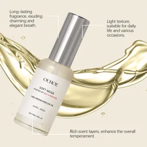 Close-up van OUHOE Soft Musk parfumolie fles met gouden vloeistofspatten op achtergrond