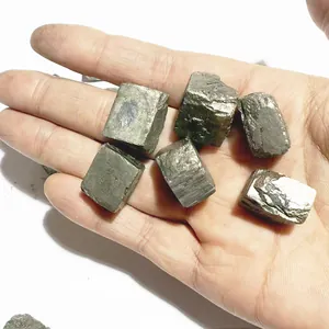 Makro-Detail von rohen kubischen Pyritkristallen in der Handfläche mit metallischem Glanz