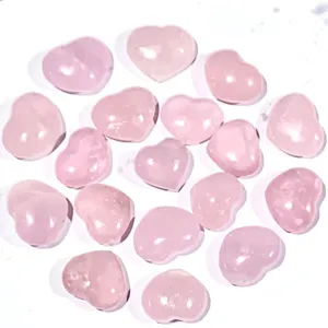 Gros plan de pierres de quartz rose naturel en forme de cœur sur fond blanc