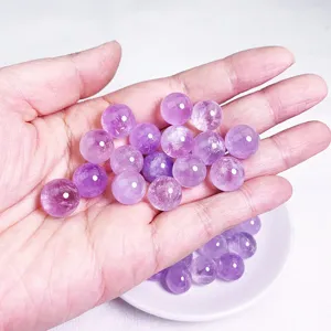 Macro view of polished natural amethyst crystal beads held in hand for DIY jewelry