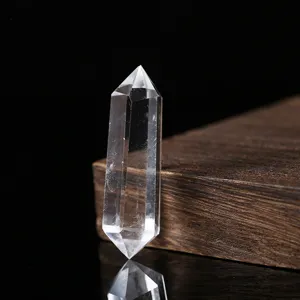 Detaillierte Nahaufnahme einer klaren Quarz-Doppelspitze auf einem dunklen Holz