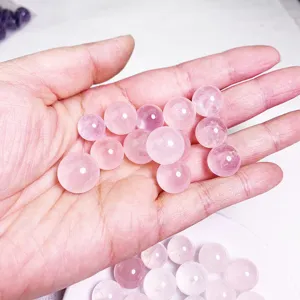 Macro view of translucent pink rose quartz beads held in a palm for DIY jewelry