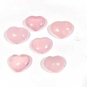 Vue détaillée de plusieurs pierres en quartz rose naturel poli en forme de cœur rose