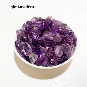Macro view of natural polished light amethyst crystal gravel displayed in a white bowl