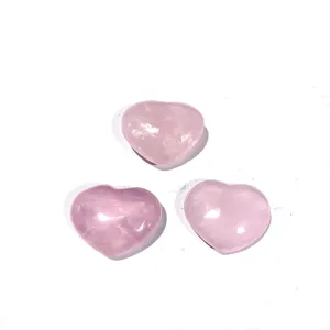 Trois magnifiques cœurs en quartz rose naturel poli présentés sur un fond blanc