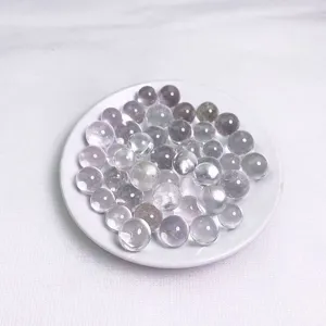 Close-up of translucent natural crystal beads for DIY jewelry in a white ceramic dish