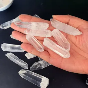 Collection de pointes de cristal de quartz clair polies sur fond noir dans la main