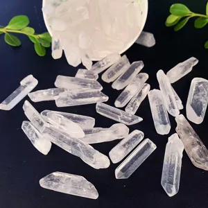 Gros plan de pointes de cristal de roche naturel poli éparpillées sur fond noir.