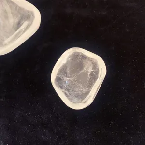 Gros plan sur un bol irrégulier en cristal de roche naturel sur velours noir.