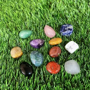 Vue détaillée de diverses pierres de cristal naturel polies et colorées sur herbe verte