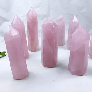 Detailed close-up showing multiple rose quartz hexagonal crystal prisms on a white base