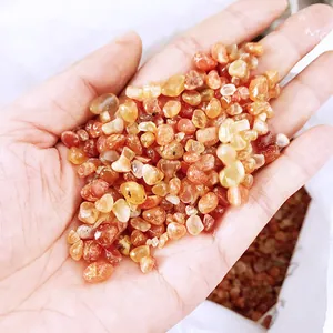 Detailed close-up showing polished natural red carnelian agate stones held in a hand